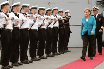 ميركل تستعرض عناصر من البحرية الألمانية (رويترز)