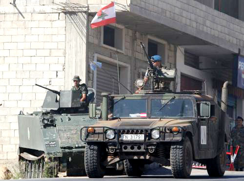 آلية إسبانية تمرّ قرب آلية تابعة للجيش اللبناني (رويترز)